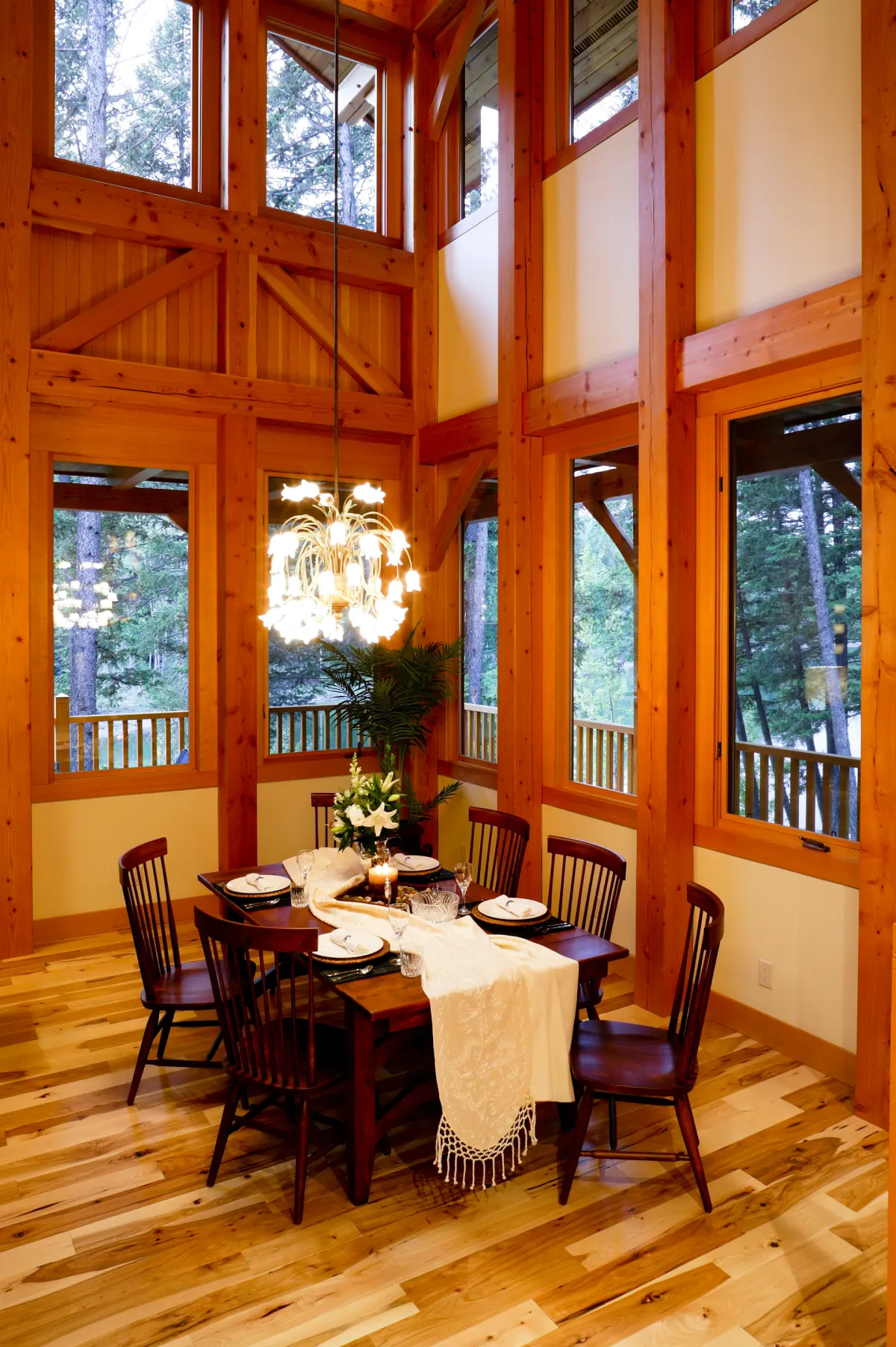 A dining room with two story ceilings shows the beauty of a timber constructed home